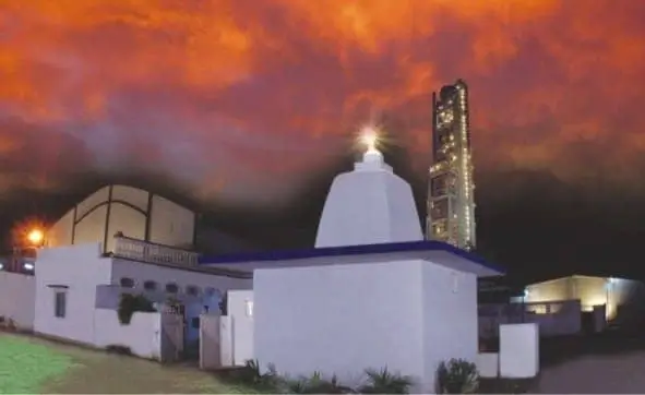 A white building with a tower in the background on a campus in Ahmednagar, Maharashtra, India.