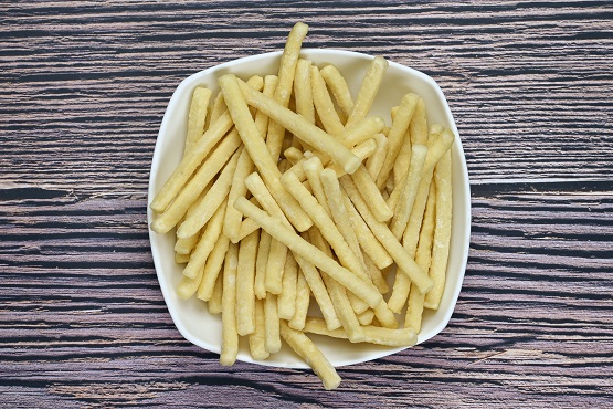 A bowl of white potato granules on a wooden table